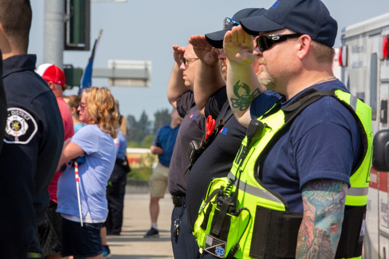 Officers salute as a procession for Clark County Sergeant Jeremy Brown, who died while on duty, passes by in Vancouver, Washington, on Tuesday, Aug. 3, 2021..